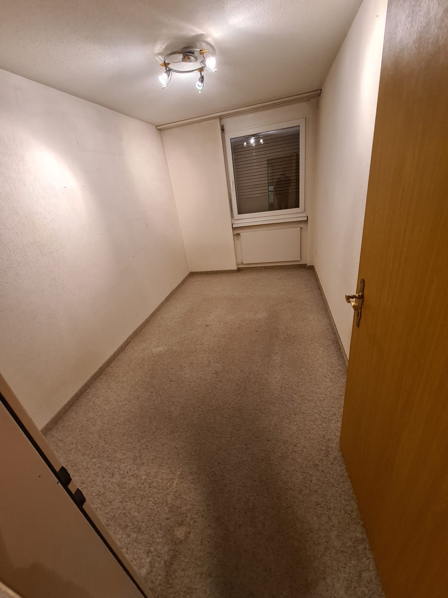 Avant : chambre à la moquette usée, murs jaunis, crépi structuré sur les murs et au plafond