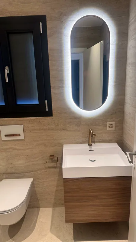 Miroir ovale éclairé et lavabo suspendu